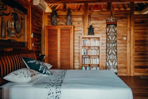 Un dormitorio con una cama en una cabaña de troncos en Kubu He Mamatica, en Tianyar