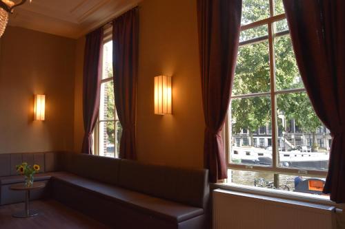 sala de estar con sofá y 2 ventanas en OZO Hotels Armada Amsterdam, en Ámsterdam