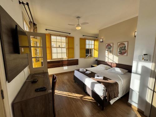 a bedroom with a bed and a table in it at Imperial Cidade Smart Suítes in Ouro Preto