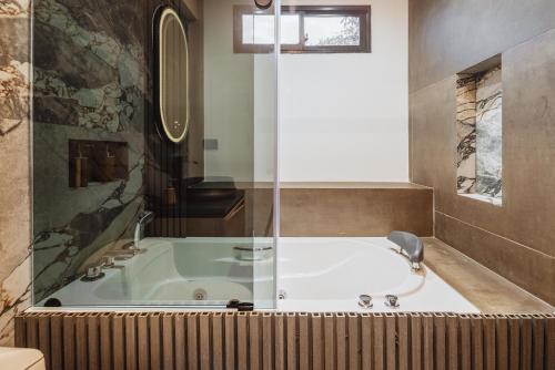 a bath tub in a bathroom with a window at Green House Hotel in Salento