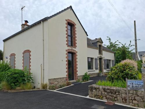 een wit gebouw met rode bakstenen ramen aan een straat bij Ty Yé in Sarzeau