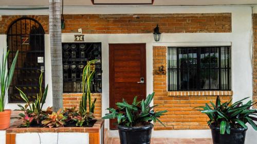 a house with potted plants in front of a door at Cozy & Fully Equipped Studio in Zona Romantica in Puerto Vallarta