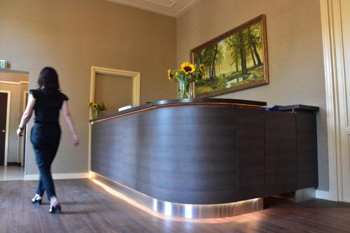 a woman walking past a desk in a room at OZO Hotels Armada Amsterdam in Amsterdam