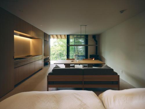 a room with two beds and a table and a kitchen at SANU 2nd Home Nasu 3rd in Nasu