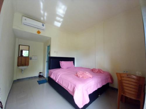 a bedroom with a pink bed with a pink blanket at Stella Dell Mare Homestay and Tour in Labuan Bajo