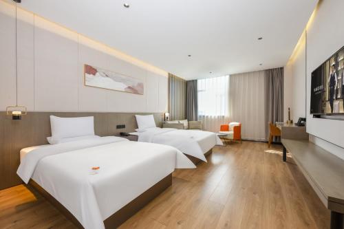 Ένα ή περισσότερα κρεβάτια σε δωμάτιο στο Jin Yi Hotel Hohhot East Railway Station Branch