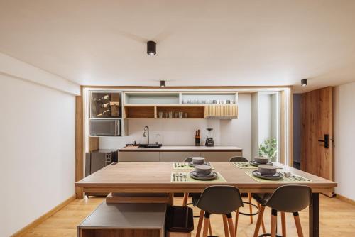 a kitchen and dining room with a wooden table and chairs at Green House Hotel in Salento