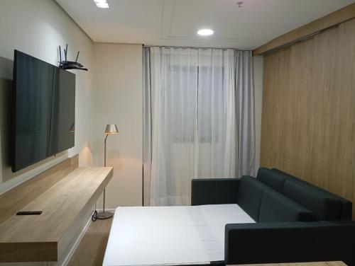 a living room with a couch and a tv at Hotel Internacional Plaza Paulista in Sao Paulo
