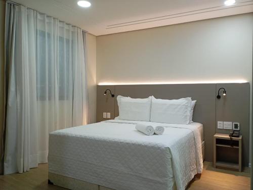 a bedroom with a large white bed with towels on it at Hotel Internacional Plaza Paulista in Sao Paulo