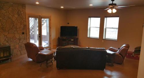 ein Wohnzimmer mit Sofa, Sesseln und Fernseher in der Unterkunft Highland Mesa Getaway in Flagstaff