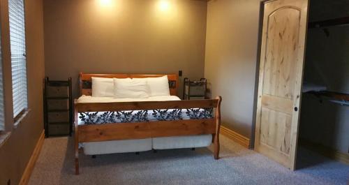 Schlafzimmer mit einem Bett mit einem Holzrahmen und einer Tür in der Unterkunft Highland Mesa Getaway in Flagstaff