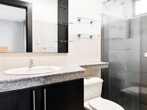 un bagno con lavandino, WC e specchio di Piscina con Bbq en Villa privada cerca de centros comerciales con 3 habitaciones, 5 Camas, seguridad 24-7 a Bellavista
