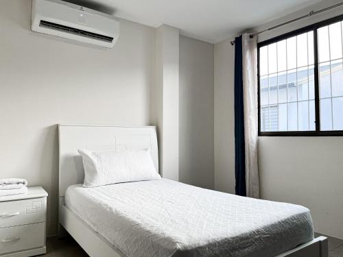 una camera da letto bianca con un letto e una finestra di Piscina con Bbq en Villa privada cerca de centros comerciales con 3 habitaciones, 5 Camas, seguridad 24-7 a Bellavista