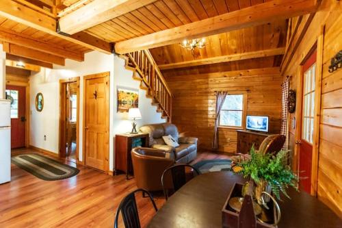 un soggiorno con tavolo e sedie in una cabina di Enchanted Forest Cabin a Winterport