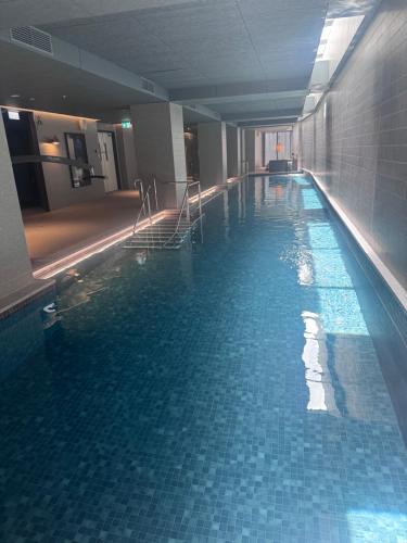a large swimming pool in a building with blue tiles at South Melbourne retreat in Melbourne