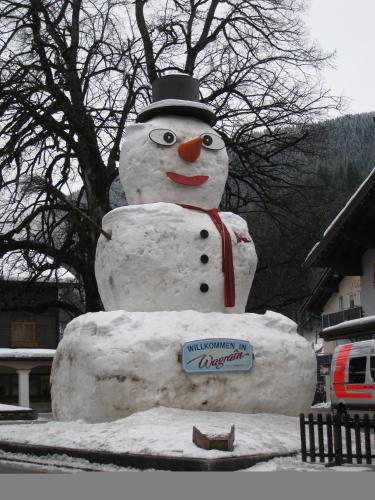a snowman statue with a top hat and a sign at Haus Katharina in Wagrain