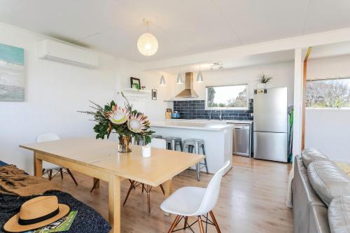 a kitchen and living room with a table and chairs at Aldinga Beach Breakaway - C21 SouthCoast Holidays in Aldinga Beach