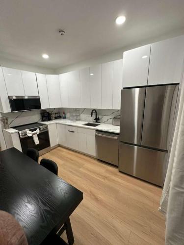 a kitchen with white cabinets and a stainless steel refrigerator at The View - Direct Bus Time Square NYC Breakfast Included - C in Jersey City