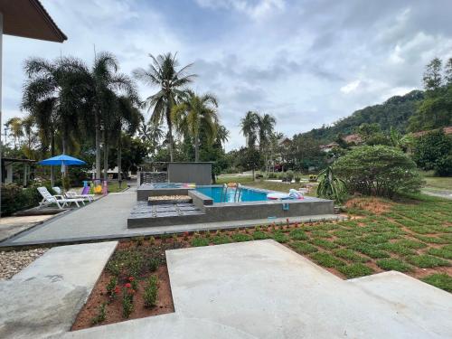 a backyard with a swimming pool and a garden at Theorenda house in Ban Taling Ngam