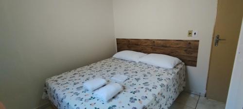 a bedroom with a bed with towels on it at Fique a vontade in Uberaba