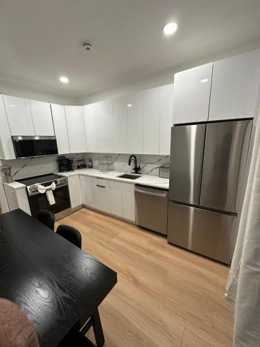 a kitchen with white cabinets and a stainless steel refrigerator at The View - Direct Bus Time Square NYC Breakfast Included - D in Jersey City