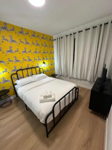 a bedroom with a large bed with a yellow wall at The View - Direct Bus Time Square NYC Breakfast Included - D in Jersey City