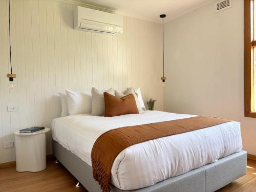 a bedroom with a large bed with white sheets and pillows at Simple Comfort: Bridport Retreat in Bridport