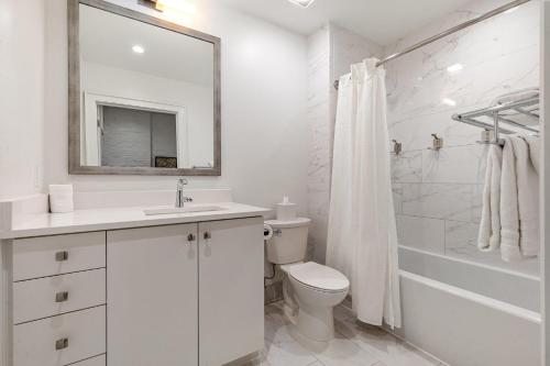 Baño blanco con aseo, lavabo y espejo en The Saddlery - Headliner - Walk to Broadway, en Nashville