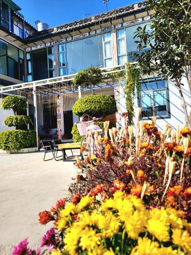 a garden in front of a house with flowers at DALI FLOWER&CAT VILLa in Dali