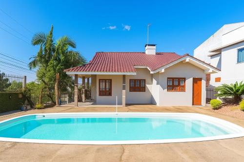 una casa con piscina delante de una casa en Casa c Piscina Gigante, Lareira e Churrasqueira, en Campo Bom
