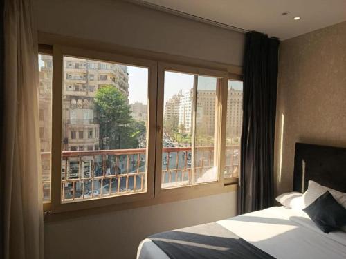 カイロにあるlotus view El tahrirのベッド1台と窓2つが備わるホテルルームです。