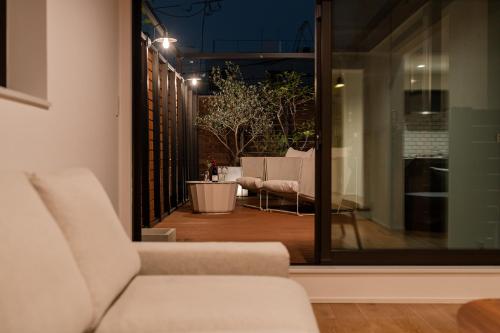 a living room with a couch and a patio at Villa Shibuya East , 渋谷東ヴィラ in Tokyo
