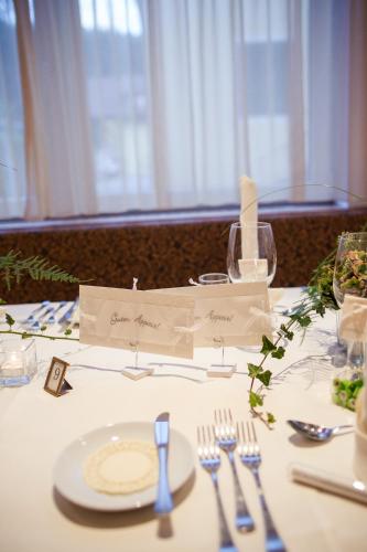 a table with a white plate and silverware on it at Hotel Blitzburg in Brunico