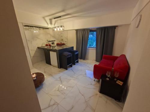 Una sala de estar con un sofá rojo y una cocina. en Departamento Vicco, en Pinamar