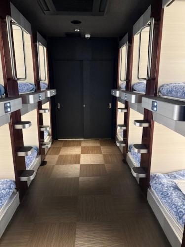 a room with three bunk beds on a train at Kawaramachi Gion Onsen Golden Time Takamatsu (Male Only) in Takamatsu