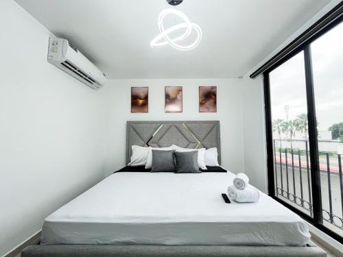 una camera da letto bianca con un letto grande e una finestra di Villa con piscina privada y BBQ, 3 habitaciones, 5 camas, seguridad 24-7 a Amalia