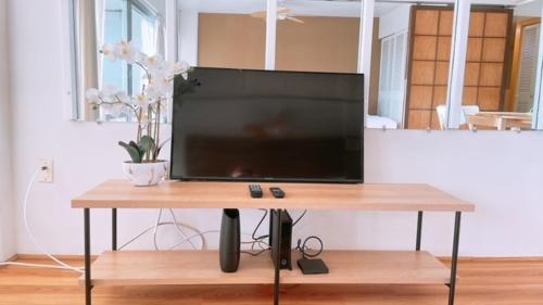 a flat screen tv sitting on top of a wooden table at Ocean view studio with parking in Honolulu