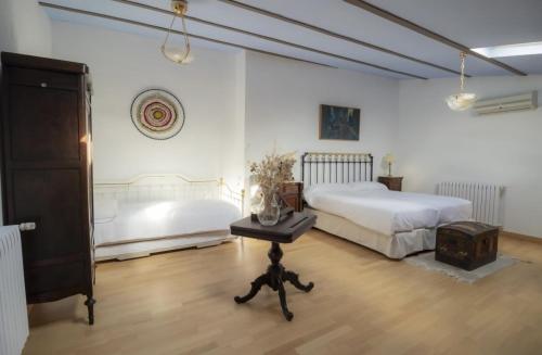 ein Schlafzimmer mit einem Bett und einem Tisch in einem Zimmer in der Unterkunft Casa rural Casa Leles in Lagata
