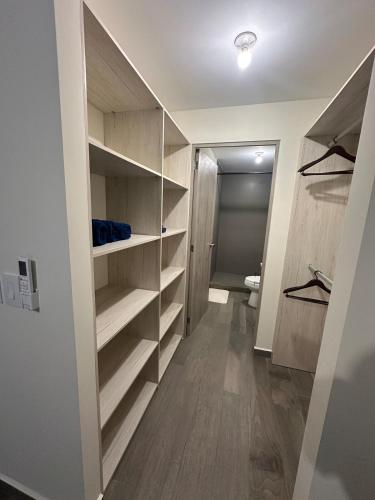 a walk in closet with wooden shelves in a room at NU Lomas Garden in Antiguo Cuscatlán