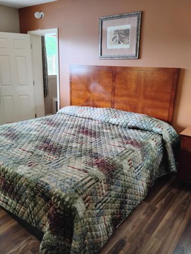 een slaapkamer met een bed met een houten hoofdeinde bij Gated - 1 King Bed 1 Bath Apt with Full Kitchen 111 in Baton Rouge
