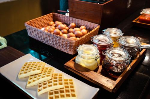 un tavolo con un vassoio di uova, waffle e barattoli di miele di Pandawa Hill Resort a Nusa Dua