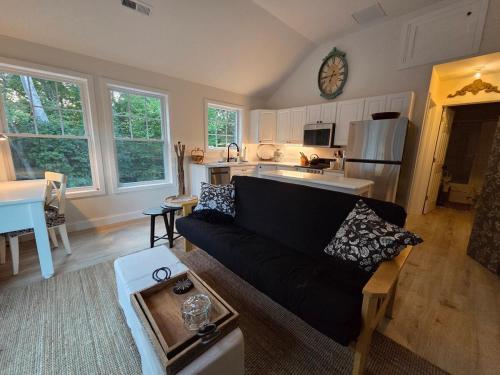 een woonkamer met een zwarte bank en een keuken bij Perch, for work or wandering the Litchfield Hills in Southbury