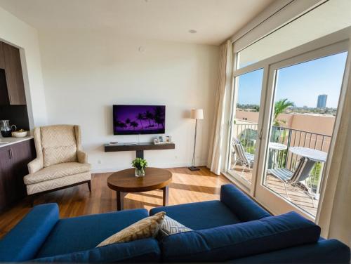 a living room with a blue couch and a large window at Boutique KTown Stays With Breathtaking Rooftop Views in Los Angeles
