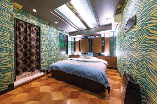 a bedroom with a bed in a room with green walls at Himeji Park Hotel (Adult Only) in Himeji