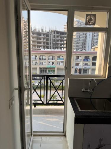 a kitchen with a view of a city from a window at Guest Stay Inn 1BHK in Zirakpur
