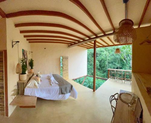 una camera da letto con un letto e una grande finestra di Cabaña El Mamoncillo con Jacuzzi Privado y Malla Catamarán a Sopetrán