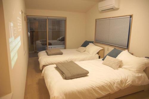 two beds in a small room with a window at Tateshina Infinity Grand - Vacation STAY 40443v in Yukawa