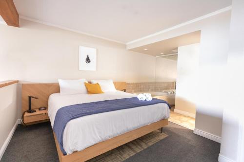 a bedroom with a large bed and a bathroom at Bonnie View Inn in Haliburton