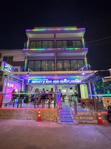 a group of people sitting at a table in front of a building at Moggy s Bar And Guest House in Pattaya Central