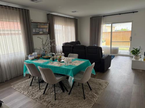 a dining room with a green table and chairs at Radhika Kutir in Perth